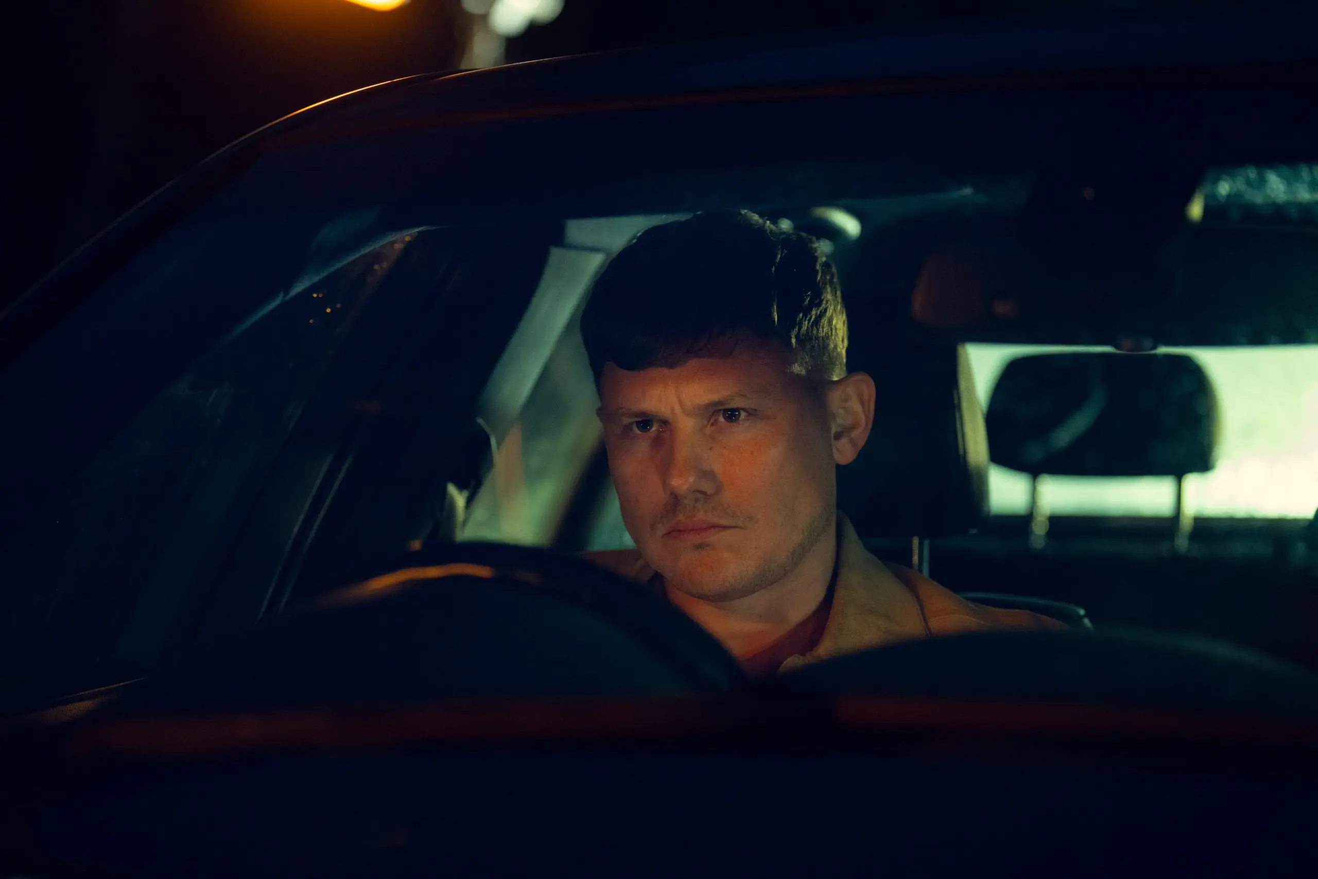 Snapshot of Tv programme, man sat in front seat of car