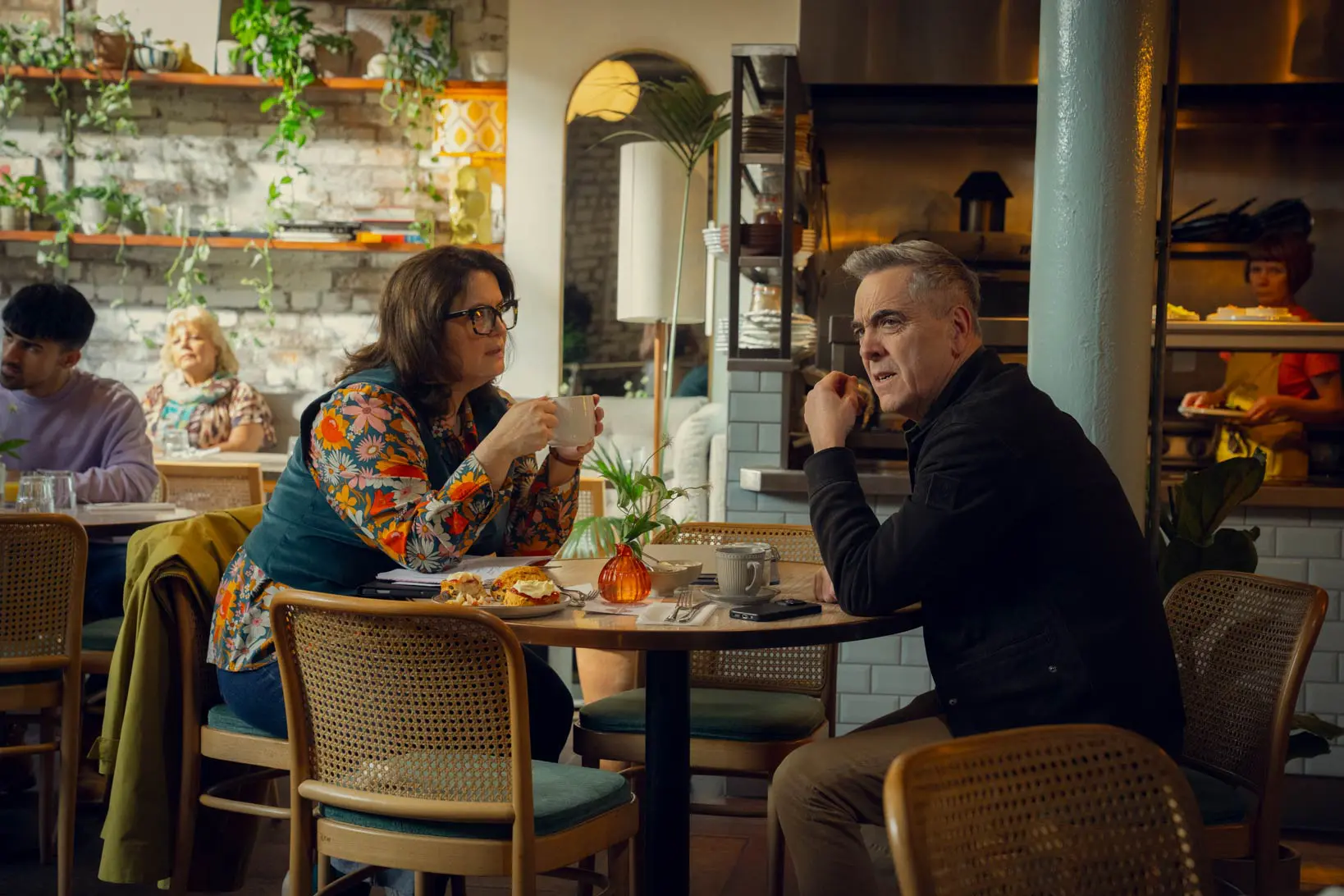 Two people talking indoors at a cafe/restaurant