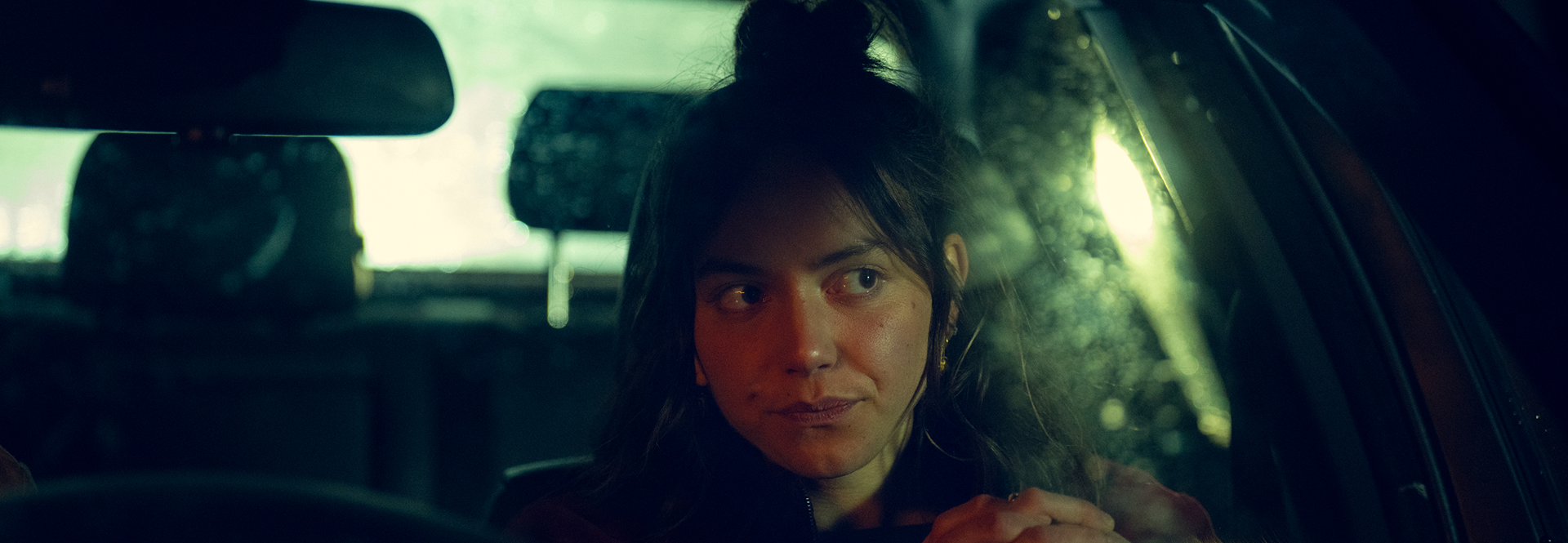 Snapshot of Tv programme, woman sat in front seat of car