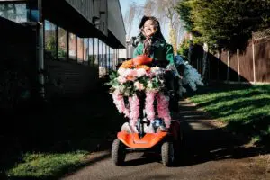 Woman carrying large bouquet of flowers outdoors