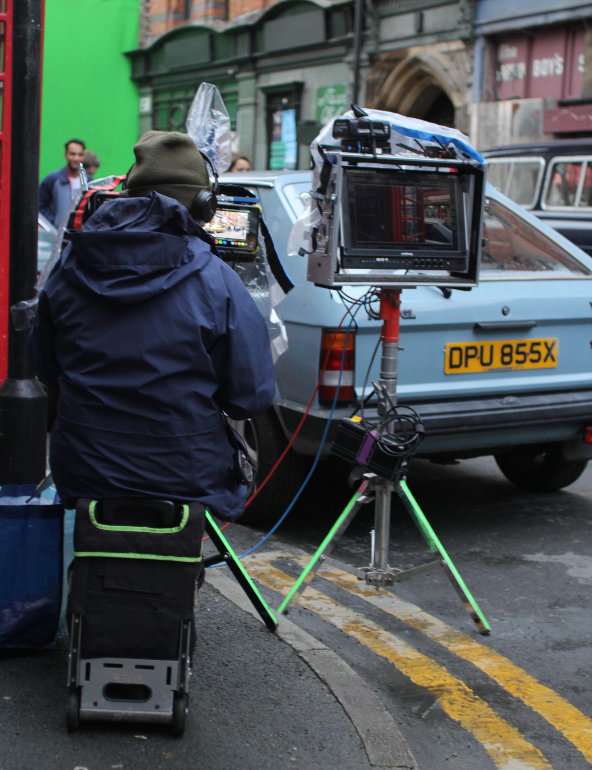 Film crew operating camera equipment outdoors in city centre