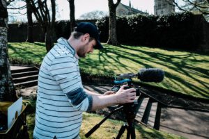 Film crew operating camera equipment outdoors