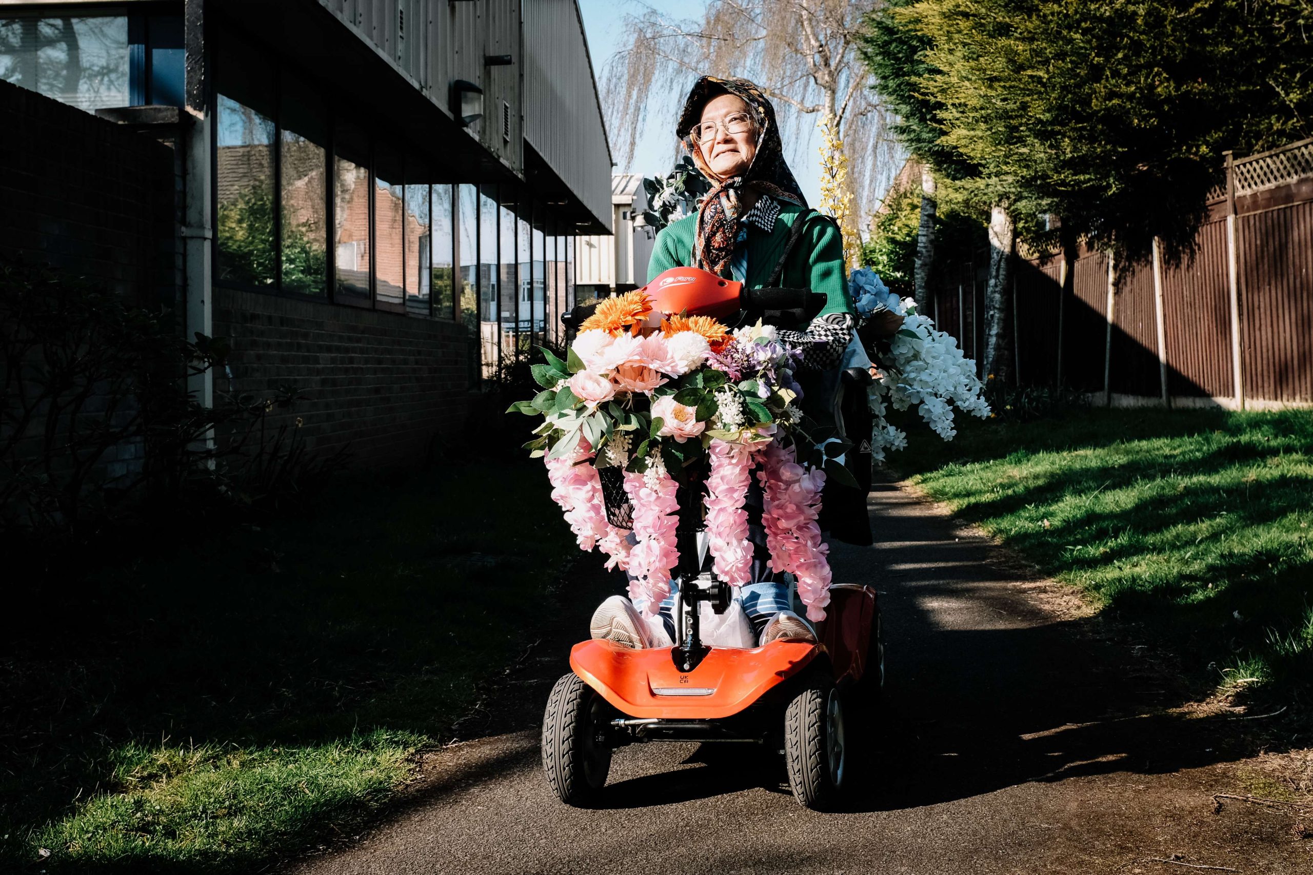 Woman carrying large bouquet of flowers outdoors